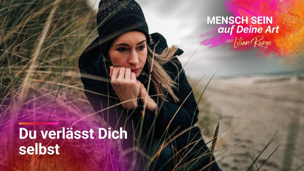 Lilian sitzt in Stranddünen und schaut nachdenklich